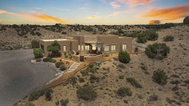 59 Sky Mountain Rd, Placitas, NM 87043 - view of front of house featuring stucco siding, a chimney, and view of desert