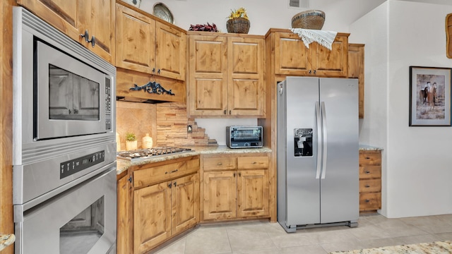 59 Sky Mountain Rd, Placitas, NM 87043 - kitchen with appliances with stainless steel finishes, tasteful backsplash, light tile patterned flooring, and light stone counters