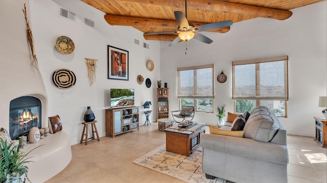 59 Sky Mountain Rd, Placitas, NM 87043 - living area with wooden ceiling, light tile patterned flooring, ceiling fan, beamed ceiling, and a fireplace