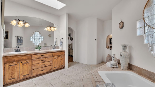 59 Sky Mountain Rd, Placitas, NM 87043 - full bath with double vanity, a relaxing tiled tub, tile patterned floors, and a skylight