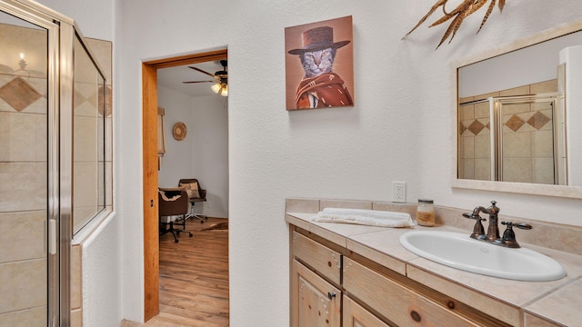 59 Sky Mountain Rd, Placitas, NM 87043 - bathroom with a stall shower, a ceiling fan, wood finished floors, vanity, and a textured wall