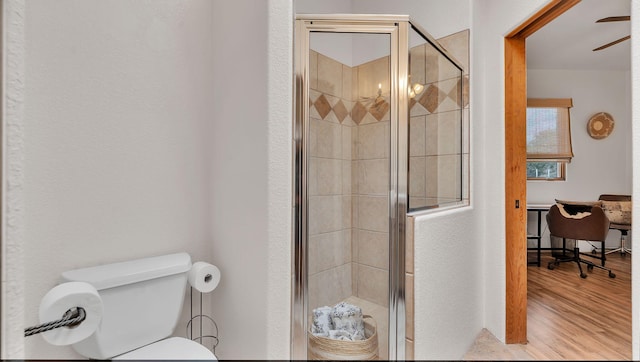 59 Sky Mountain Rd, Placitas, NM 87043 - bathroom with a stall shower, wood finished floors, toilet, and ceiling fan