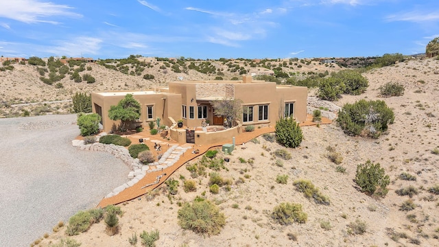 59 Sky Mountain Rd, Placitas, NM 87043 - pueblo-style home with a desert view, stucco siding, and a chimney