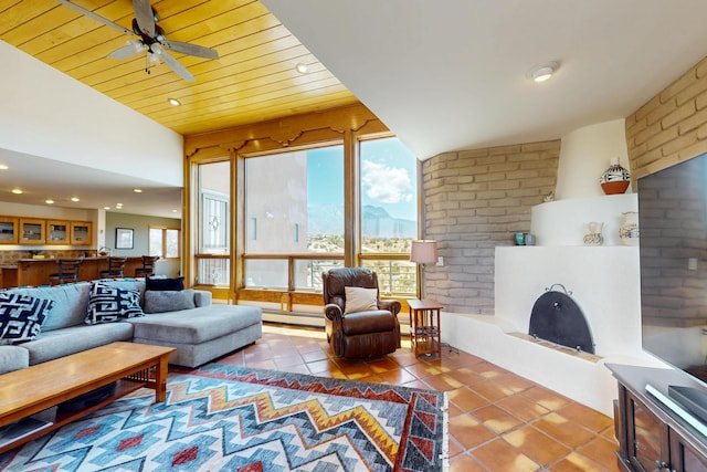 52 Tejon Canon Rd, Placitas, NM 87043 - living area with tile patterned flooring, a baseboard heating unit, recessed lighting, ceiling fan, and brick wall