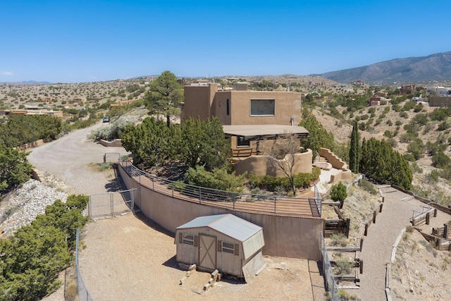 52 Tejon Canon Rd, Placitas, NM 87043 - exterior space with fence, an outdoor structure, a mountain view, a storage shed, and stucco siding