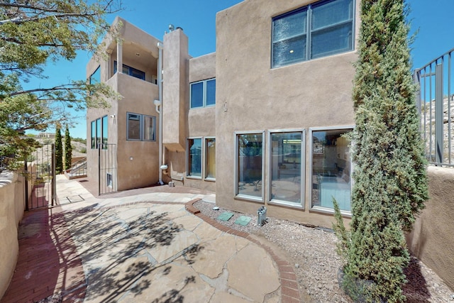 52 Tejon Canon Rd, Placitas, NM 87043 - rear view of house featuring stucco siding and a patio