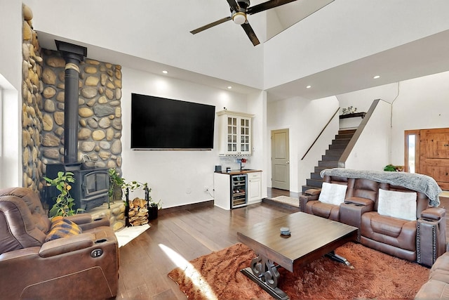 420 Bassett Blvd, Edgewood, NM 87015 - living area featuring a ceiling fan, a high ceiling, a wood stove, beverage cooler, and dark wood-style floors