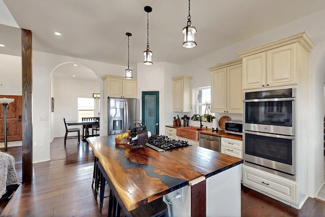 420 Bassett Blvd, Edgewood, NM 87015 - kitchen featuring cream cabinets, stainless steel appliances, wooden counters, arched walkways, and recessed lighting