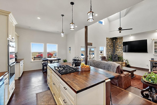 420 Bassett Blvd, Edgewood, NM 87015 - kitchen with wood counters, a wood stove, dark wood-type flooring, stainless steel appliances, and recessed lighting