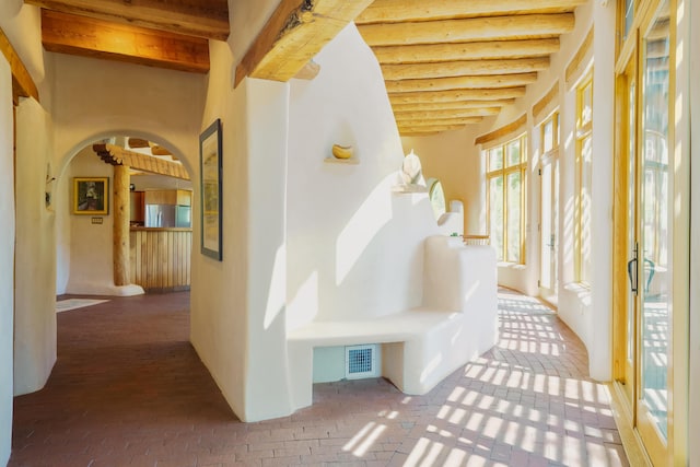 59 Perdiz Canyon Rd, Placitas, NM 87043 - corridor featuring beamed ceiling, arched walkways, and brick floors