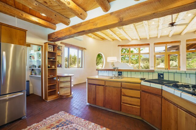 59 Perdiz Canyon Rd, Placitas, NM 87043 - kitchen with freestanding refrigerator, wooden ceiling with exposed beams, tile countertops, a sink, and plenty of natural light