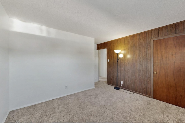 1614 Del Monte Trl SW, Albuquerque, NM 87121 - unfurnished room with wooden walls, carpet, baseboards, and a textured ceiling
