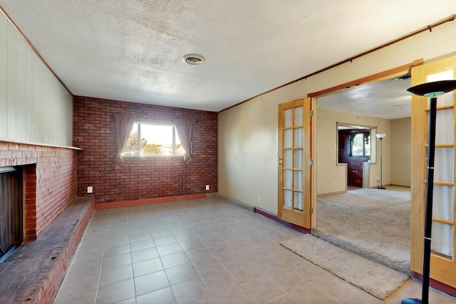 1614 Del Monte Trl SW, Albuquerque, NM 87121 - unfurnished living room with brick wall, a fireplace, tile patterned floors, and a textured ceiling