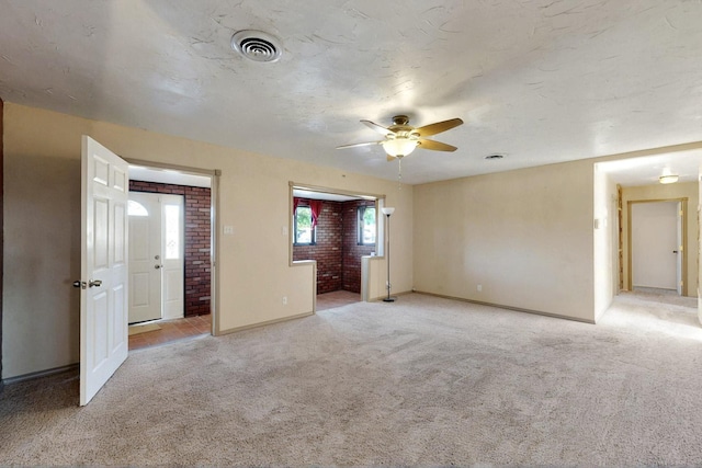 1614 Del Monte Trl SW, Albuquerque, NM 87121 - unfurnished room with light carpet, ceiling fan, baseboards, and brick wall