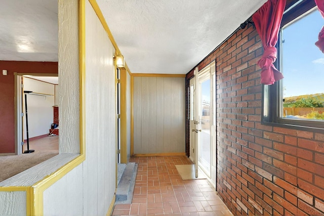 1614 Del Monte Trl SW, Albuquerque, NM 87121 - corridor with brick patterned flooring, a textured ceiling, baseboards, and wood walls