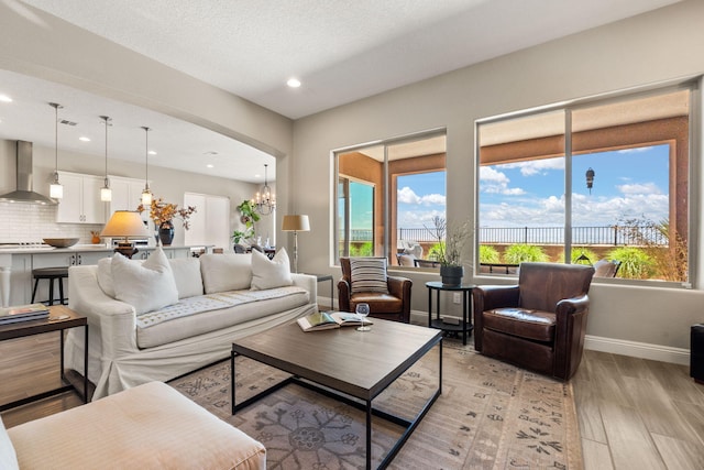 6808 Vista Luces St NW, Albuquerque, NM 87120 - living area with light wood-type flooring, a chandelier, baseboards, recessed lighting, and arched walkways