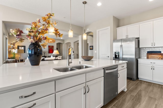 6808 Vista Luces St NW, Albuquerque, NM 87120 - kitchen featuring a sink, stainless steel appliances, arched walkways, light countertops, and recessed lighting