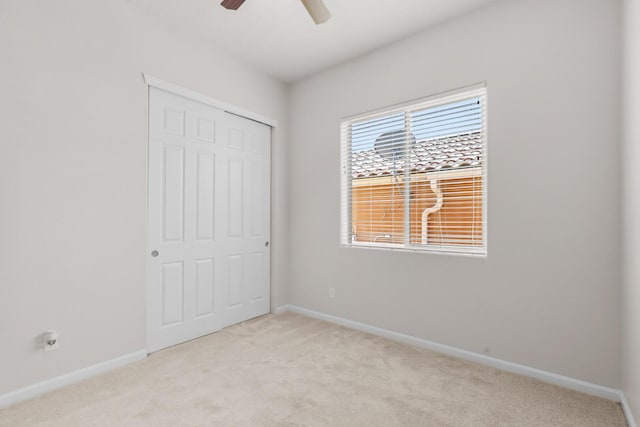 729 Sierra Verde Way NE, Rio Rancho, NM 87124 - unfurnished bedroom featuring light carpet, a closet, baseboards, and a ceiling fan
