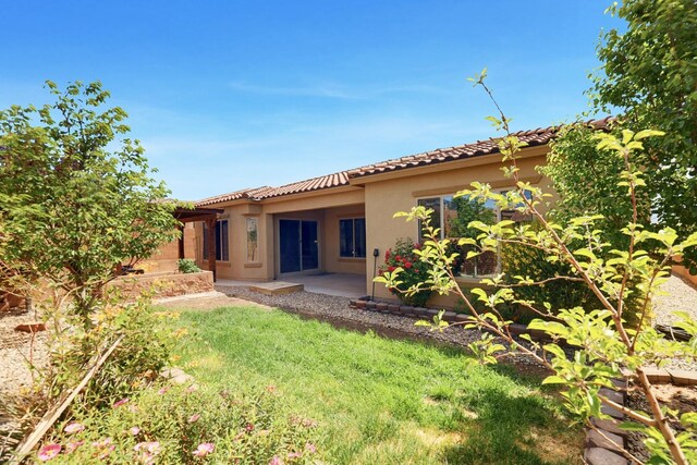 729 Sierra Verde Way NE, Rio Rancho, NM 87124 - back of property featuring stucco siding, a tiled roof, and a lawn