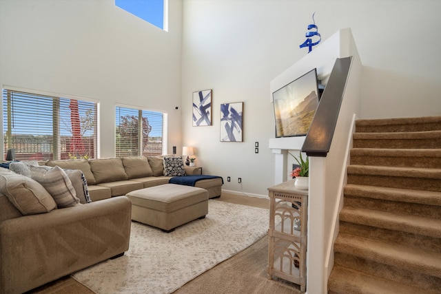 3604 Plano Vista Rd NE, Rio Rancho, NM 87124 - carpeted living room featuring a towering ceiling, stairs, healthy amount of natural light, and baseboards