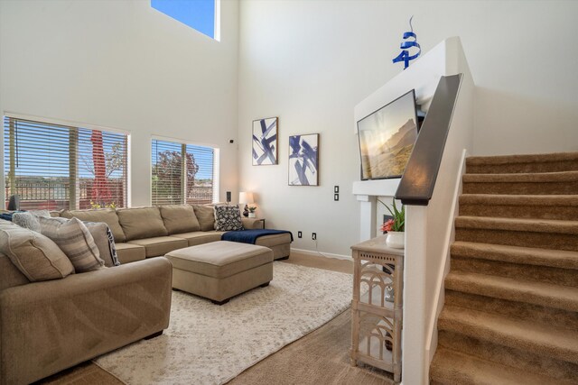3604 Plano Vista Rd NE, Rio Rancho, NM 87124 - carpeted living room featuring a high ceiling, stairs, and healthy amount of natural light