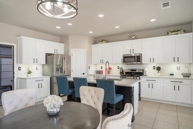 3604 Plano Vista Rd NE, Rio Rancho, NM 87124 - kitchen with appliances with stainless steel finishes, a sink, a center island with sink, white cabinetry, and light countertops