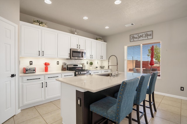 3604 Plano Vista Rd NE, Rio Rancho, NM 87124 - kitchen featuring stainless steel appliances, a sink, a breakfast bar, tasteful backsplash, and an island with sink