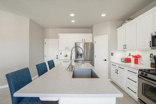 3604 Plano Vista Rd NE, Rio Rancho, NM 87124 - kitchen with stainless steel appliances, a sink, backsplash, an island with sink, and light tile patterned flooring