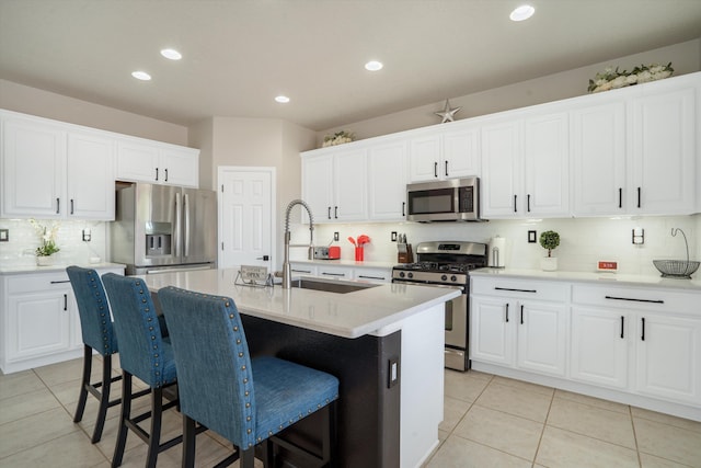 3604 Plano Vista Rd NE, Rio Rancho, NM 87124 - kitchen with stainless steel appliances, a sink, backsplash, a breakfast bar, and white cabinetry