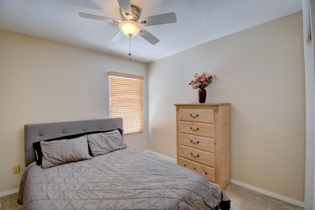 carpeted bedroom with baseboards, a ceiling fan, and a textured ceiling