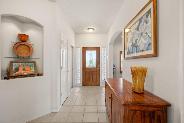 3916 Alamogordo Dr NW, Albuquerque, NM 87120 - foyer entrance featuring arched walkways, light tile patterned floors, and baseboards