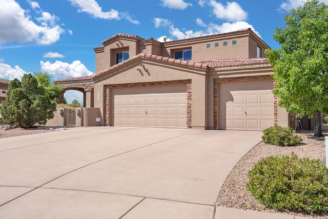 3916 Alamogordo Dr NW, Albuquerque, NM 87120 - mediterranean / spanish-style house with concrete driveway, stucco siding, a garage, and a gate