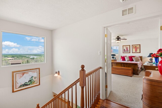 3916 Alamogordo Dr NW, Albuquerque, NM 87120 - hallway with an upstairs landing, a textured ceiling, and wood finished floors