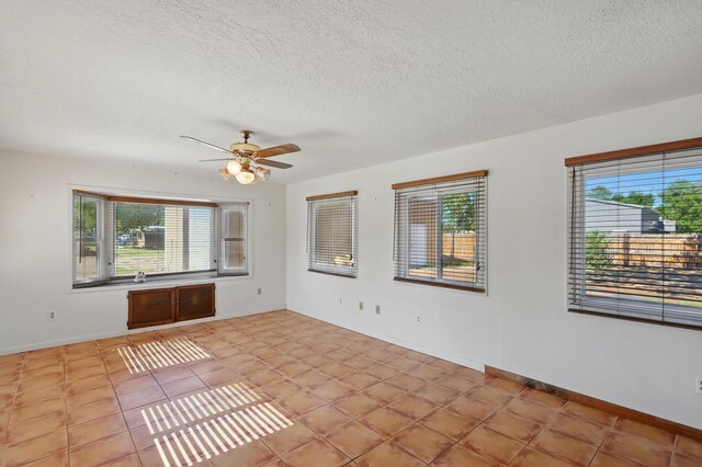 1595 W Bosque Loop, Bosque Farms, NM 87068 - empty room featuring plenty of natural light, a ceiling fan, a textured ceiling, and light tile patterned flooring