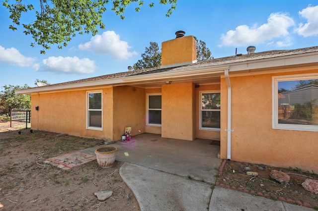 1595 W Bosque Loop, Bosque Farms, NM 87068 - rear view of property with a chimney, a patio, and stucco siding