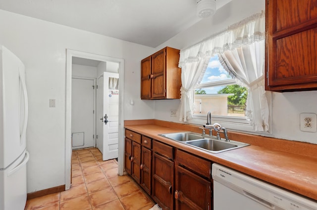 1595 W Bosque Loop, Bosque Farms, NM 87068 - kitchen featuring white appliances, light countertops, light tile patterned floors, and brown cabinets