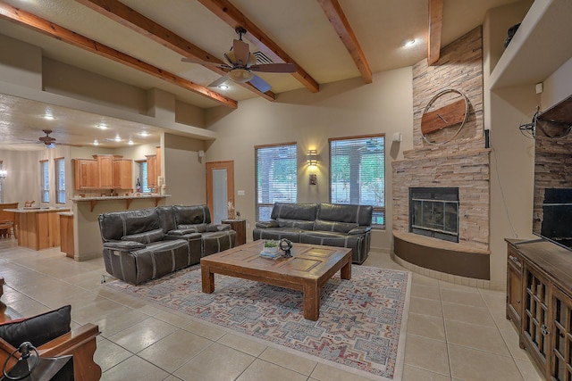 3924 Bay Hill Loop SE, Rio Rancho, NM 87124 - living room with a ceiling fan, beam ceiling, light tile patterned floors, a stone fireplace, and a high ceiling