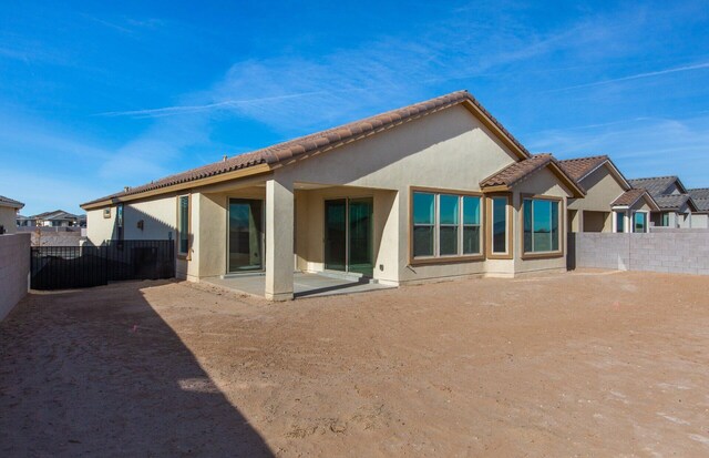 8328 Bronte Ln NW, Albuquerque, NM 87120 - back of house with a patio, stucco siding, fence, and a tiled roof