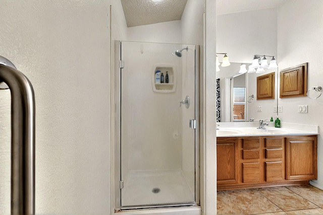 1250 Carnival Ave NW, Los Lunas, NM 87031 - bathroom featuring a shower stall, double vanity, tile patterned flooring, and a textured ceiling