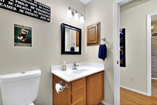 1250 Carnival Ave NW, Los Lunas, NM 87031 - bathroom with vanity, toilet, wood finished floors, and baseboards