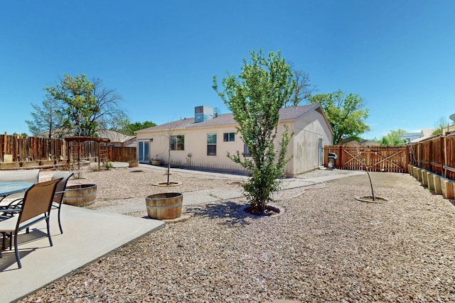 1321 Elkslip Dr NE, Rio Rancho, NM 87144 - back of house featuring a patio, a fenced backyard, a gate, and a fire pit