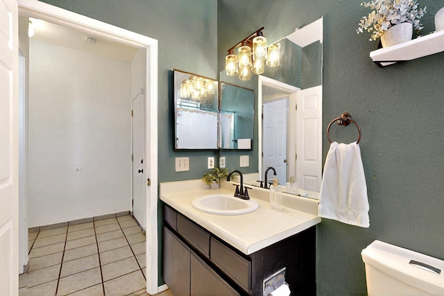 1321 Elkslip Dr NE, Rio Rancho, NM 87144 - bathroom featuring tile patterned floors, toilet, vanity, a chandelier, and a textured wall