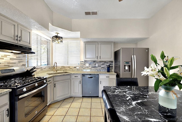 1321 Elkslip Dr NE, Rio Rancho, NM 87144 - kitchen featuring appliances with stainless steel finishes, a sink, under cabinet range hood, tasteful backsplash, and light tile patterned floors