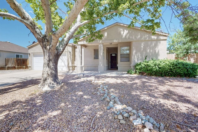 1321 Elkslip Dr NE, Rio Rancho, NM 87144 - view of front of house featuring stucco siding, fence, driveway, and a garage