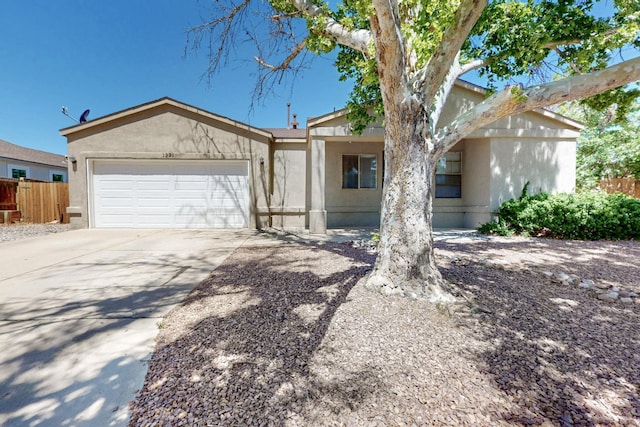 1321 Elkslip Dr NE, Rio Rancho, NM 87144 - view of front facade with stucco siding, fence, an attached garage, and concrete driveway