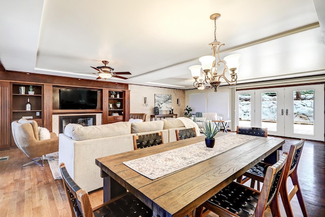 1106 Warm Sands Dr SE, Albuquerque, NM 87123 - dining space featuring a chandelier, a raised ceiling, wood finished floors, french doors, and a ceiling fan