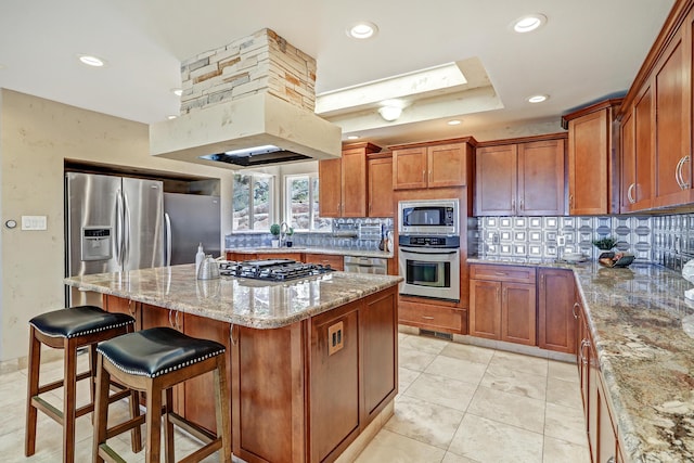 1106 Warm Sands Dr SE, Albuquerque, NM 87123 - kitchen featuring stainless steel appliances, tasteful backsplash, light stone countertops, a sink, and a center island