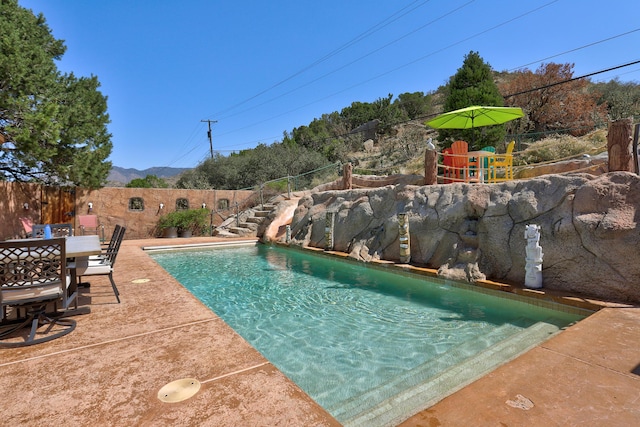 1106 Warm Sands Dr SE, Albuquerque, NM 87123 - view of swimming pool featuring a water slide, a fenced backyard, a patio, and outdoor dining space
