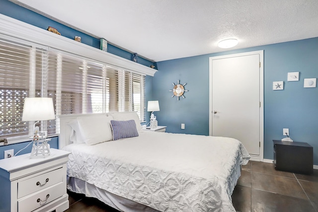 1106 Warm Sands Dr SE, Albuquerque, NM 87123 - bedroom featuring a textured ceiling, baseboards, and dark tile patterned flooring