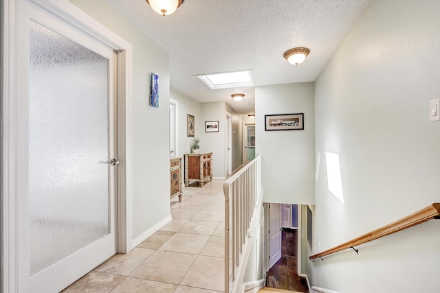 1106 Warm Sands Dr SE, Albuquerque, NM 87123 - corridor with an upstairs landing, light tile patterned flooring, baseboards, and a textured ceiling
